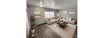 A living room with a white couch, a coffee table, and a plant.